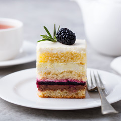 Vanilla, chocolate layered cake on white plate. Grey background. Close up.