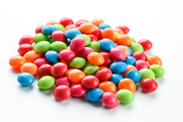 Rainbow-colored candies, multicolored close-up, texture and repetition of dragee