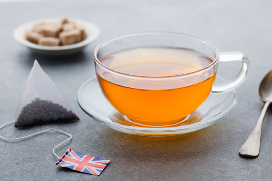 Tea cup with British flag tea bag label. Grey background. Close up.