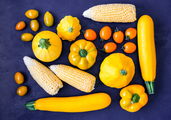 Obraz na płótnie Canvas Assorted types of yellow vegetables on blue background. Top view