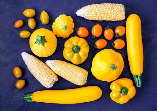 Assorted types of yellow vegetables on blue background. Top view
