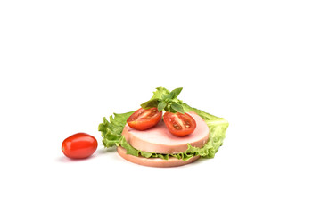 Two pieces of boiled sausage with sliced tomatoes and a leaf of lettuce on a white background. Traditional Russian sausage.