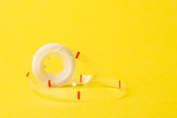 empty reel of musical tape on yellow background