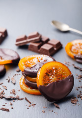 Candied orange slices in chocolate. Slate background. Copy space.