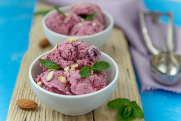 Ice cream with berries. Ice cream balls in a white bowl with nuts and mint.