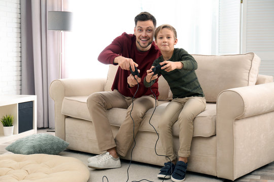 Father And Son Playing Video Games At Home