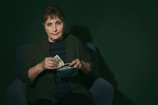 Poor senior woman with money on color background. Space for text