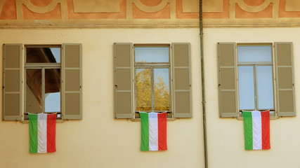 Bandiere italiane sulle finestre di un palazzo storico