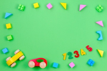 Baby kid toy background. Colorful wooden cubes, cars and numbers on green background