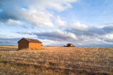 Era de pueblo en paisaje otoñal con casetas o cabañas de adobe que se usaban para guardar los aperos de la trilla