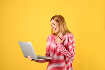 Naklejka premium Woman using laptop for video chat on color background