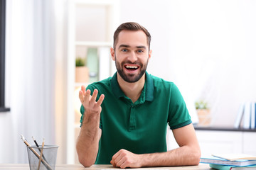 Handsome man using video chat for conversation indoors