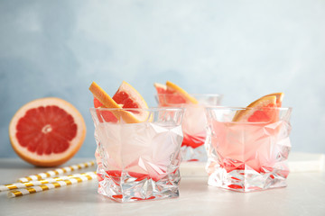 Glasses with tasty grapefruit cocktails on table