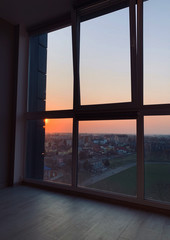 Panoramic windows overlooking beautiful golden sunset. View from home window