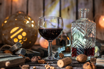 Red wine on a wooden table in front of a wooden background with a creative lighting