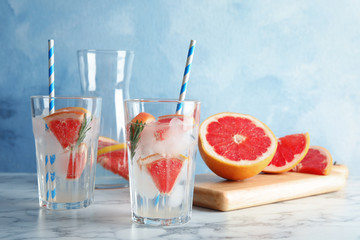 Glasses of infused water with grapefruit slices on table. Space for text