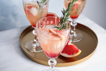 Glass of grapefruit cocktail on table, closeup