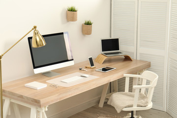 Stylish workplace interior with modern computer on table. Mockup for design