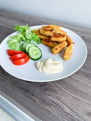 Fried mozzarella cheese sticks breaded on white plate