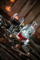 Red wine on a wooden table in front of a wooden background with a creative lighting