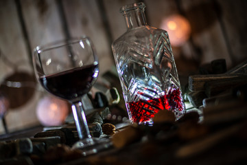 Red wine on a wooden table in front of a wooden background with a creative lighting