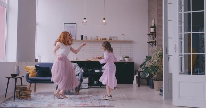 Mother dancing with daughter in the room