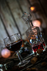 Red wine on a wooden table in front of a wooden background with a creative lighting