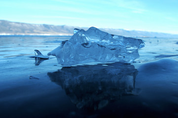 the sun's rays are refracted in crystal clear pieces of ice. winter landscape. Lake Baikal