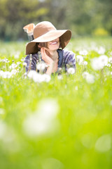 Happy spring woman on dandelion field enjoying spring warm days	