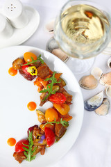 Salad from vegetables and rapanov meat. Meat shells rapanov from the Sea of Azov. Grilled vegetables with a great sauce. Blackberry top view. Still life concept.