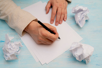 Pen in man's hand. White sheet of paper. Signing document.