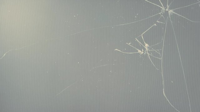 An ominous flickering neon light over an lcd pc screen shot or video with a broken glass.