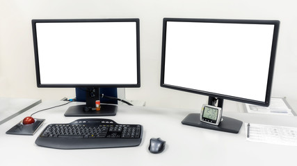 Two computer monitors are on the table in the office. On the monitors white screen to insert images or text