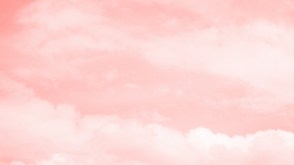 Pink coral color sky background with white clouds. 16:9 panoramic format. Coral gradient background