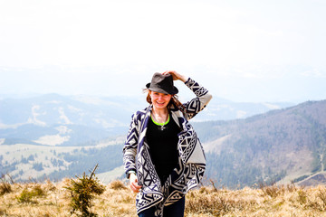 Rudy girl in the mountains in a poncho. Carpathian Mountains. Traveling tours
