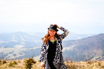 Rudy girl in the mountains in a poncho. Carpathian Mountains. Traveling tours