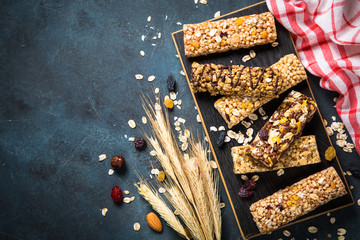 Granola bar with nuts, fruit and berries on black.
