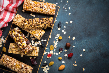 Granola bar with nuts, fruit and berries on black.