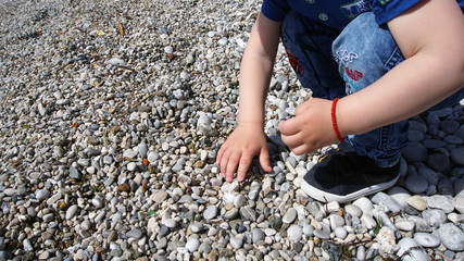 Child is playing on a rocky beach