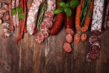 cold meat assortment with delicious salami and  fresh herbs . Variety of meat products including coppa and sausages
