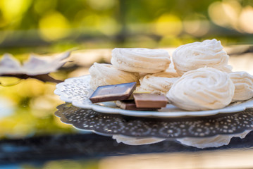 marshmallows and chocolate in a white plate on a background