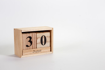 Wooden calendar June 30 on a white background