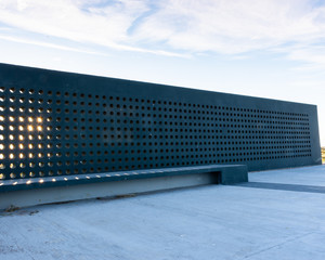 Metal wall, concrete floor and clouds with shadows.