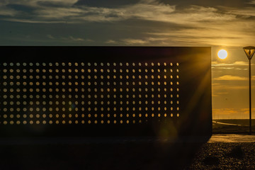  Metal wall, concrete floor and clouds with shadows, sunset with some clouds.