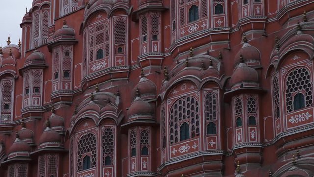 Wide shot panning across the front of the Hawa Mahal palace in Jaipur showing the decorative design and architecture