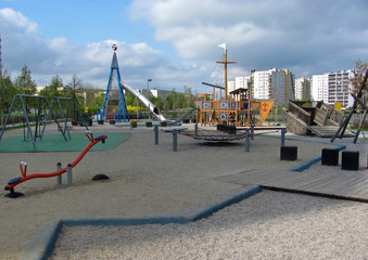 Fototapeta na wymiar Children playground on yard in public park. Urban neighborhood childhood concept.