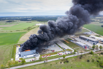 Aerial view of burnt industrial warehouse or logistics center building after big fire with huge smoke from burned roof - 266613508