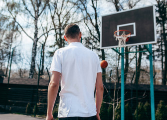 Young man wearing white blank polo, playing streetball