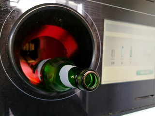 Beer bottle inserted in the automatic reverse vending machine for recycling