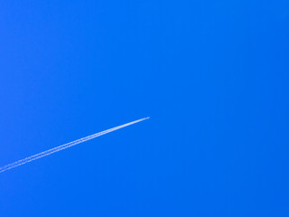 airplane contrail against clear blue sky with copy space